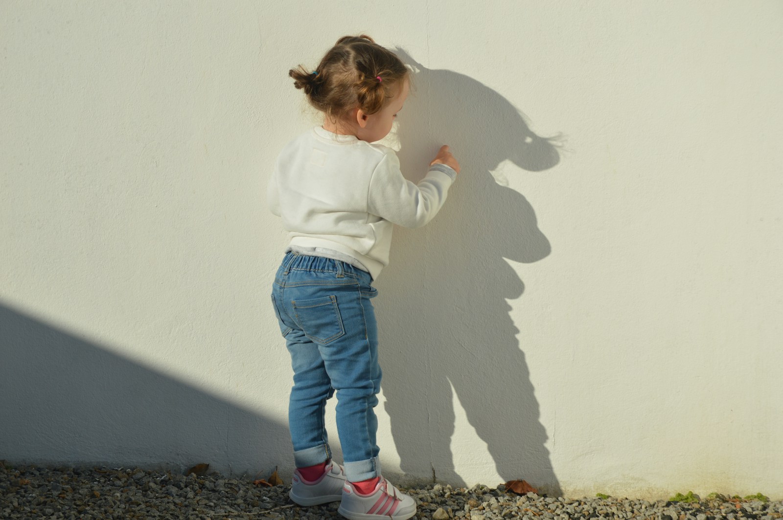 Photo by Susana Coutinho child touching white painted wall during daytime