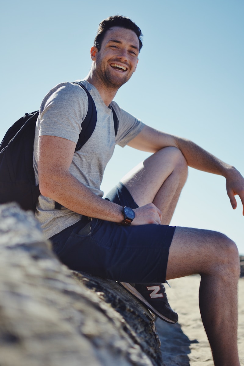 Photo by Stephanie Tuohy Smiling man sitting on gray rock at daytime