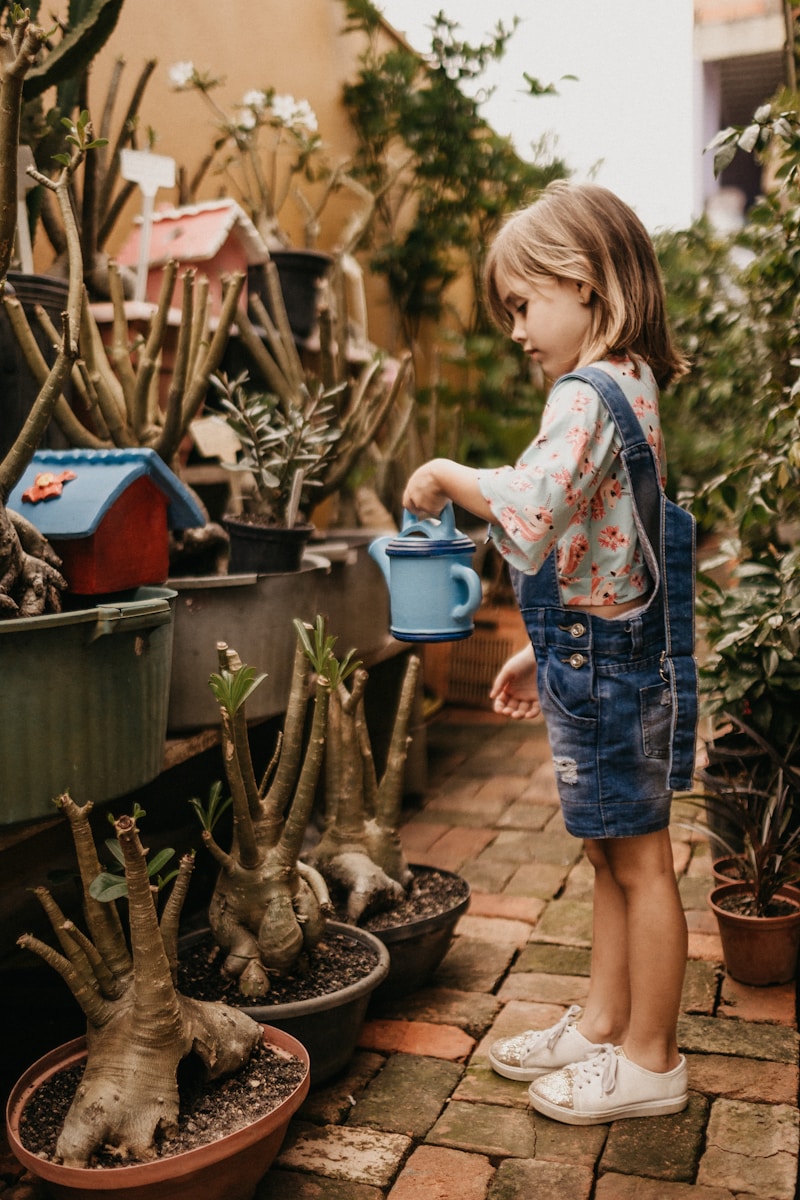 Photo by Jonathan Borba girl wearing blue romper holding teal watering can