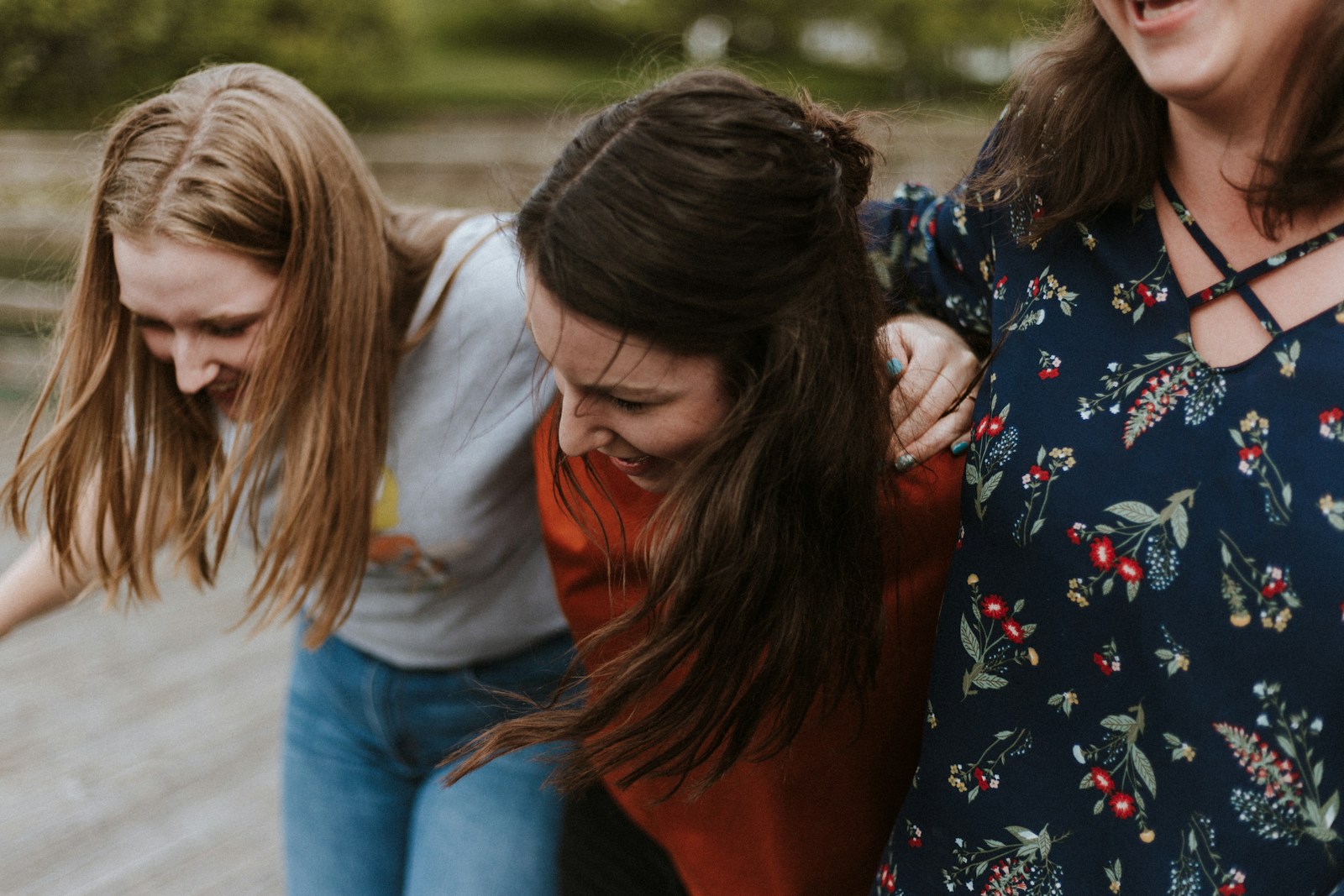 Photo by Priscilla Du Preez 🇨🇦 three woman holding each other and smiling while taking a photo